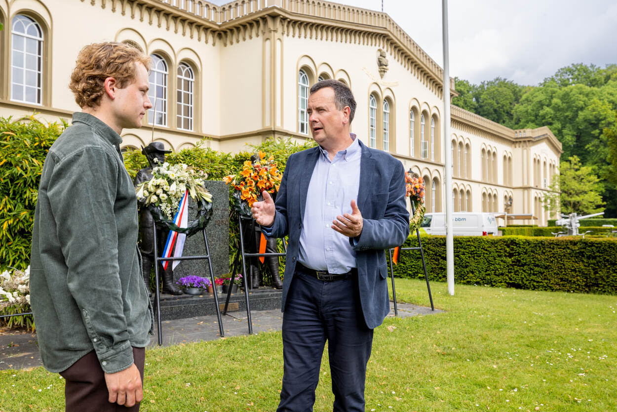 Peter Kool van Defensie praat met Geels voor kransen die zijn gelegd bij een herdenking