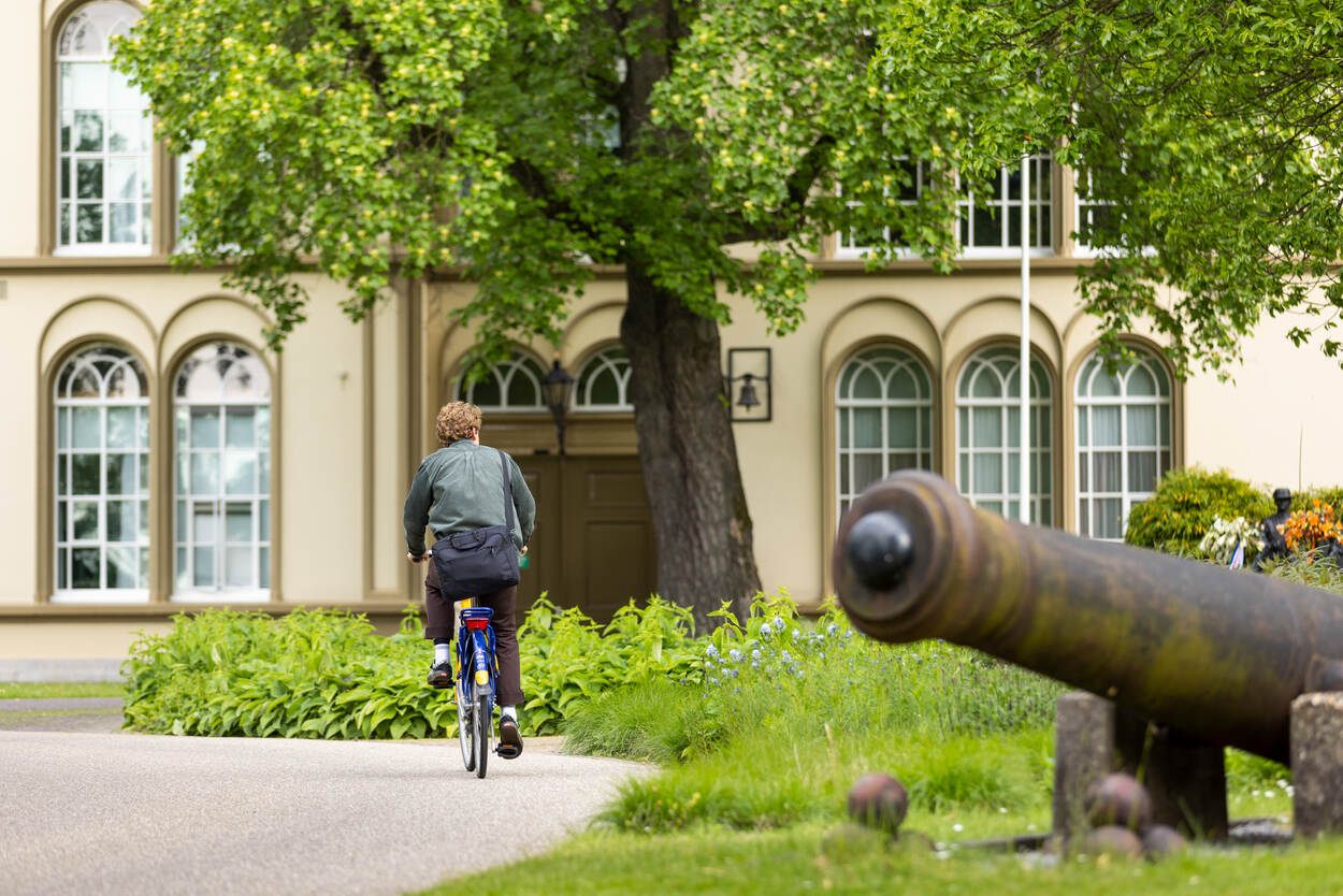 Daan Geels komt het terrein van landgoed Bronbeek op gefietst