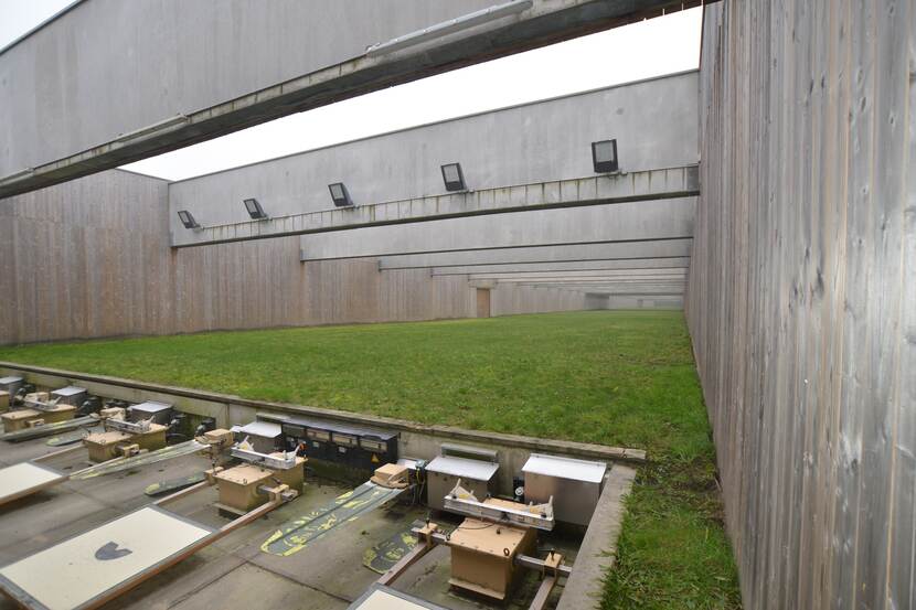Grote oefenschietbaan in de buitenlucht met aan de bovenkant grote betonnen balken. De schietschijven zijn goed te zien.