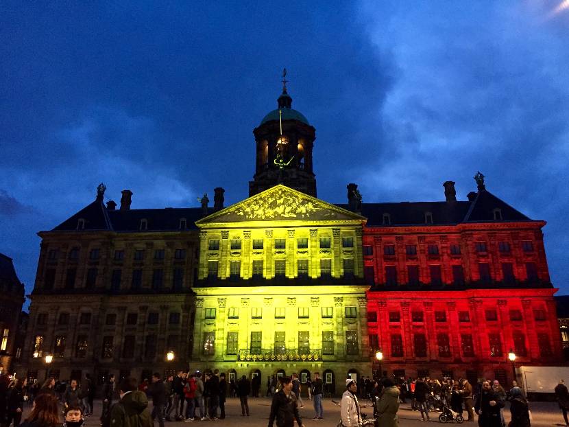 Koninklijk Paleis Amsterdam verlicht in kleuren Belgische vlag