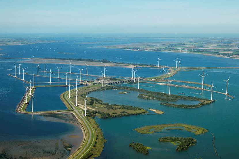 Luchtfoto van windmolens in een waterrijk landschap.