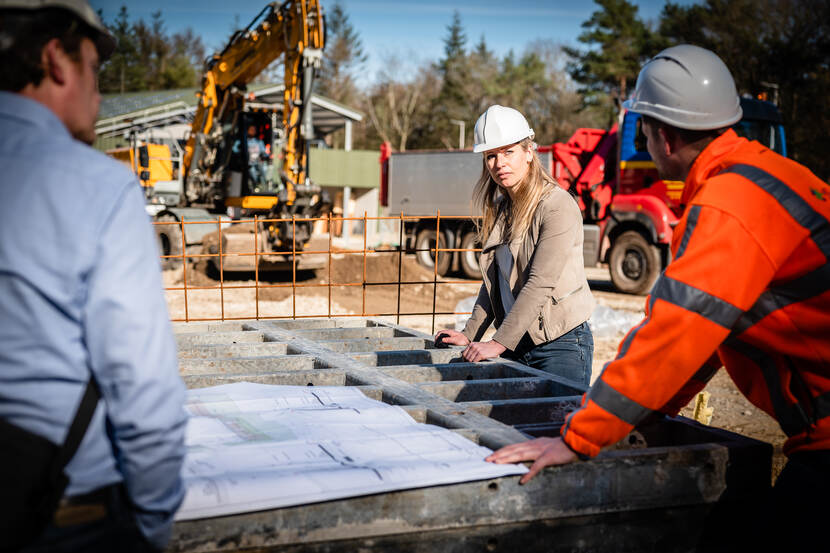 Leonie van Ham, projectleider bij het Rijksvastgoedbedrijf, in overleg op een bouwplaats