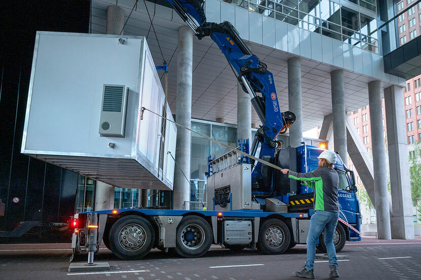 Grote stadsbatterij wordt met touwen onder het kantoor aan de Rijnstraat getakeld